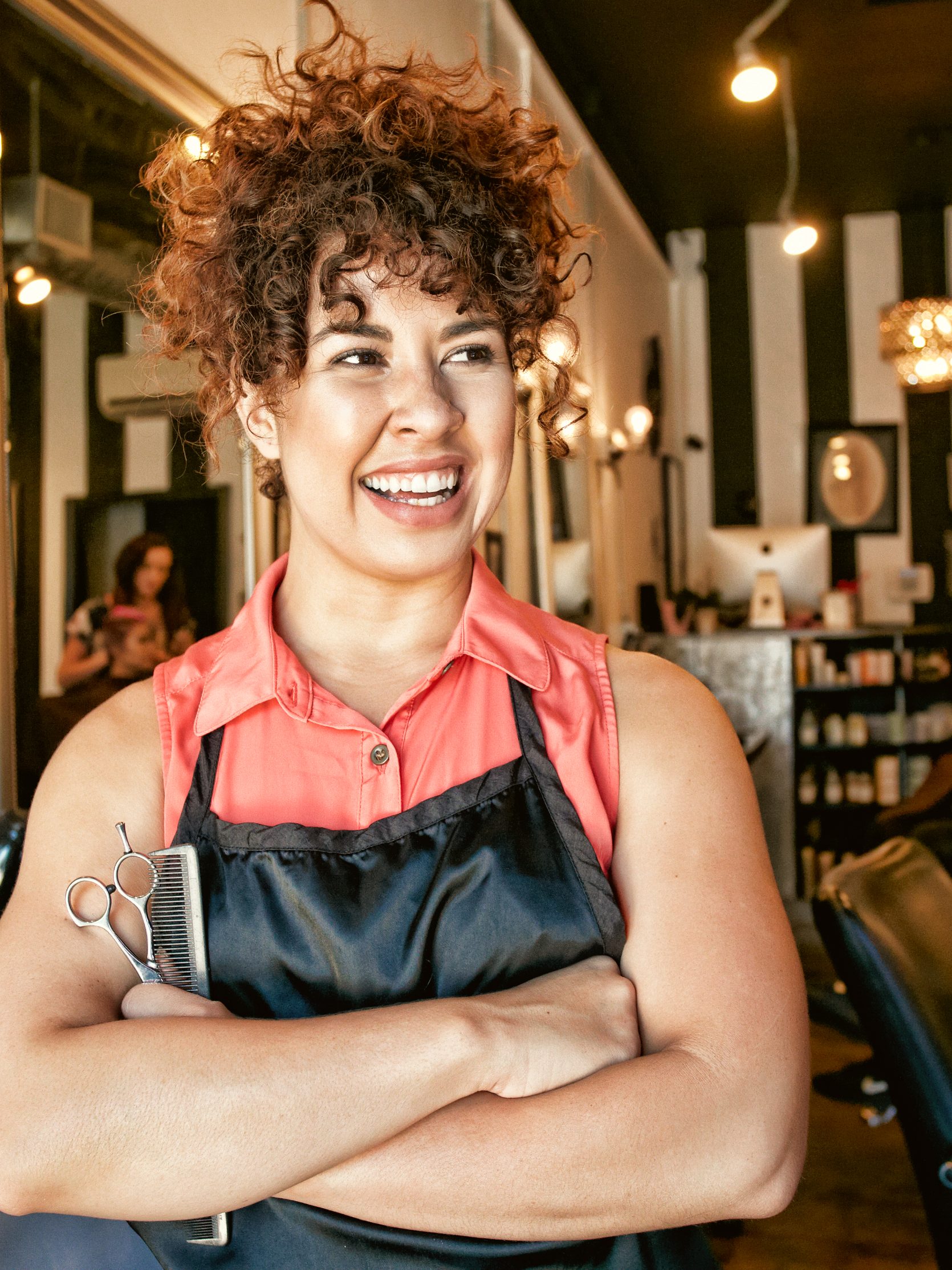 A female hair salon owner smiles at a customer.
